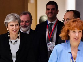 British Prime Minister Theresa May (L) arriving at a breakfast meeting of a summit with European Union (EU) leaders at the European Council headquarter in Brussels, on March 23, 2018.