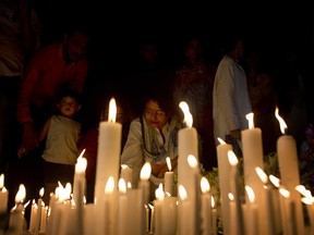Bangladeshi people light candles to pay homage to the victims of Monday's plane crash in Kathmandu, as they gather in front parliament building in Dhaka, Bangladesh, Thursday, March 15, 2018.