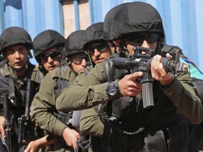In this Sunday, March 18, 2018 photo, Palestinian security forces participate in a training drill on how to retake a police station that has come under attack, at the Jordan International Police Training Center, in the Jordanian town of al-Muwaqqar, about 34 miles (55 km) southeast of the capital, Amman. Jordan has become a regional center for training visiting counterterrorism forces from across the Middle East, Africa and Asia, with key programs backed by the United States.