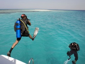 In this March 7, 2018 photo, Nouf Alosaimi, a 29-year-old female Saudi dive instructor, waits in the water for Tamer Nasr, an Egyptian diving instructor to explore the waters off a sandy island in the Red Sea near King Abdullah Economic City, Saudi Arabia. Saudi has the longest coastline of any country along the Red Sea, and the kingdom's nascent tourism industry is betting on the clear, blue waters, coral reefs and idyllic islands off its western coastline to lure visitors from around the world.