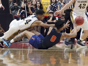 UC Irvine guard Evan Leonard (14) and Cal State Fullerton guard Kyle Allman Jr. (0) scramble for the ball during the first half of an NCAA college basketball game for the Big West men's tournament championship in Anaheim, Calif., Saturday, March 10, 2018.