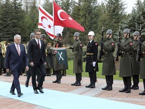 Turkish Prime Minister Binali Yildirim, left, and Tufan Erhurman, the prime minister of the self-declared Turkish Cypriot state in the north of the divided island, review a military honour guard during a ceremony at the Cankaya Palace in Ankara, Turkey, Wednesday, March 7, 2018.