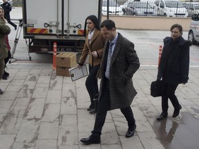 Hakan Yalcintug, center, and Simge Sandir, left, lawyers for two arrested Greek soldiers, arrive at the courthouse in Edirne, Turkey, Monday, March 5, 2018. The lawyers for two Greek soldiers arrested in Turkey have formally requested their release from custody. The two were arrested last week for allegedly entering a Turkish military zone and on suspicion of attempted espionage.