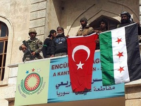 Turkish and a Turkey-backed Free Syrian Army soldiers wave Turkish and FSA flags in the city centre of Afrin, northwestern Syria, early Sunday, March 18, 2018.