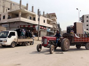 Residents who fled fighting return to the city center of Afrin, northwestern Syria, Monday, March 19, 2018, a day after Turkish troops and allied Free Syrian Army fighters took the control of the area. Turkey's President Recep Tayyip Erdogan said Monday following victory in Syria's Afrin region, his country will expand its military operations into other Kurdish-held areas in Syria as well as in Iraq's Sinjar region.