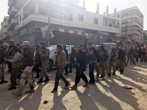 Turkey-backed Free Syrian Army soldiers walk in city center of Afrin, northwestern Syria, early Sunday, March 18, 2018. Turkey's President Recep Tayyip Erdogan said Sunday that allied Syrian forces have taken "total" control of the town center of Afrin, the target of a nearly two-month-old Turkish offensive against a Syrian Kurdish militia, which said fighting was still underway. Erdogan said the Turkish flag and the flag of the Syrian opposition fighters have been raised in the town, previously controlled by the Kurdish militia known as the People's Defense Units, or YPG.