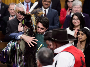 Prime Minister Justin Trudeau hugs a drummer following a performance after delivering a statement of exoneration on behalf of the Government of Canada to the Tsilhqot'in Nation and the descendants of six Tsilhqot'in Chiefs, on Monday, March 26, 2018.