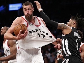 Brooklyn Nets guard D'Angelo Russell grabs the jersey of Raptors centre Jonas Valanciunas during their game Tuesday night  in New York. The Raptors beat the Nets 116-102.