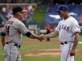 Houston Astros manager AJ Hinch, left, and Texas Rangers manager Jeff Banister, right, greet each other at home plate during team introductions before an opening day baseball game in Arlington, Texas, Thursday, March 29, 2018.