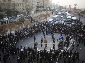 Ultra orthodox Jews block the entrance toJerusalem during a military draft protest, Thursday, March 8, 2018. Israel has compulsory military service for most Jewish men, but the ultra-Orthodox, whose political parties enjoy an outsized role in the country's coalition politics, have secured exemptions. Authorities still require ultra-Orthodox men to register for the draft, something to which the protesters gathered Thursday are opposed.