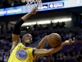 Golden State Warriors forward David West, front, and Phoenix Suns forward Jared Dudley reach for a loose ball during the first half of an NBA basketball game in Phoenix, Saturday, March 17, 2018.
