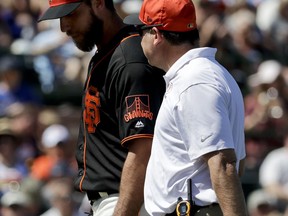 San Francisco Giants starting pitcher Madison Bumgarner is helped off the field after getting hit by a batted ball during the third inning of the team's spring training baseball game against the Kansas City Royals in Scottsdale, Ariz., Friday, March 23, 2018.