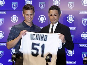 Seattle Mariners' Ichiro Suzuki, right, holds up his jersey with Mariners general manager Jerry Dipoto during a news conference at the teams' spring training baseball complex Wednesday, March 7, 2018, in Peoria, Ariz. Suzuki signed a one-year deal with the team.