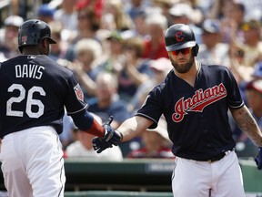 Cleveland Indians' Rajai Davis (26) celebrates his run scored as he slaps hands with Mike Napoli, right, during the first inning of a spring training baseball game against the San Diego Padres, Thursday, March 22, 2018, in Goodyear, Ariz.