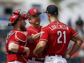 Cincinnati Reds pitching coach Mack Jenkins, center, talks with pitcher Michael Lorenzen (21) as catcher Tucker Barnhart, left, listens in during the third inning of a spring training baseball game against the Milwaukee Brewers, Friday, March 16, 2018, in Goodyear, Ariz.
