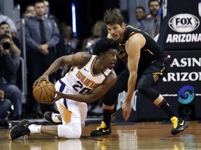 Phoenix Suns guard Josh Jackson (20) and Cleveland Cavaliers guard Kyle Korver battle for a loose ball in the first half of an NBA basketball game, Tuesday, March 13, 2018, in Phoenix.