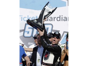 Kevin Harvick holds up the trophy after winning a NASCAR Cup Series auto race on Sunday, March 11, 2018, in Avondale, Ariz.