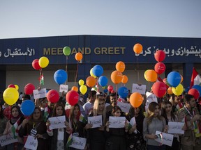 FILE - In this Sept. 29, 2017 file photo, protestors stand outside the Irbil International Airport to oppose the flight ban issued by the Iraqi federal government, in Irbil, Iraq. Prime Minister Haider al-Abadi said Tuesday, March 13, 2018, that he is reopening airports in Iraq's Kurdish region to international flights after federal authority was restored at the hubs. The announcement comes some six months after the airports were initially shut to international flights following a controversial referendum vote in northern Ira's self-ruled Kurdish region on independence from Baghdad.