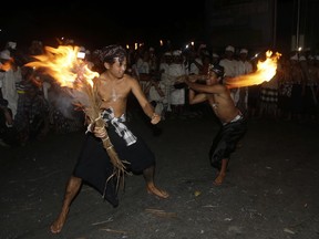 Balinese men fight with flaming coconut leaves during the fire fight ritual called 'Lukat Gni' before Nyepi, the annual day of silence marking Balinese Hindu new year, in Klungkung, Bali, Indonesia, Friday, March 16, 2018. Bali's annual Day of Silence is so sacred that even reaching for a smartphone to send a tweet or upload a selfie to social media could cause offense. This year it will be nearly impossible to do that anyway, all phone companies have agreed to shut down the mobile internet for 24 hours on Saturday during the holiday that marks the New Year on the predominantly Hindu island.