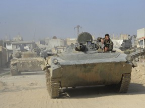 This photo released on Wednesday March 7, 2018 by the Syrian official news agency SANA, shows Syrian government soldiers, in their armored vehicle during a battle against Syrian rebels, in eastern Ghouta, Syria. The International Committee of the Red Cross said a second convoy that was supposed to carry aid to the besieged rebel-held eastern suburbs of Damascus was postponed Thursday because of the violence and rapidly evolving situation on the ground. (SANA via AP)
