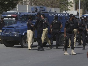 Pakistani police commandos escort an armored vehicle carrying Rao Anwar, a police officer accused of killing a 27-year-old man in an allegedly "stage-managed" shootout that sparked outrage on the part of Pakistan's tribal communities, at an anti-terrorist court in Karachi, Pakistan, Thursday, March 22, 2018.