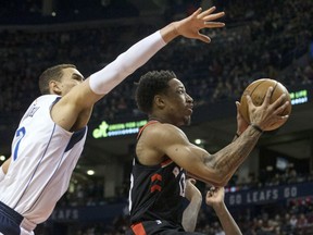 Raptors guard DeMar DeRozan shoots past Dallas Mavericks centre Dwight Powell during first half NBA action in Toronto on Friday night.