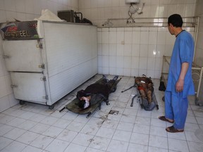Bodies of civilians lie on the ground at hospital after a suicide attack in front of the Kabul university in Kabul, Wednesday, March 21, 2018. Afghan officials are reporting a large explosion on the road to a Shiite shrine in the capital, where people had gathered to mark the Persian new year.