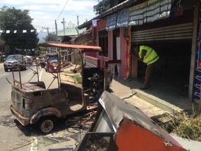 A Sri Lankan police officer investigates a burnt shop in Digana on the out skirts of Kandy, Sri Lanka, Thursday, March 8, 2018. Local residents say Buddhist mobs have swept through Muslim neighborhoods in Sri Lanka's central hills, destroying stores and restaurants despite a curfew, a state of emergency and a heavy deployment of security forces.