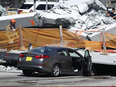 A crushed car lies under a collapsed pedestrian bridge in Miami, Florida, on March 15, 2018.