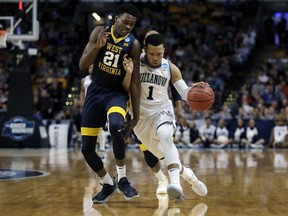 Villanova's Jalen Brunson, right, tries to dribble past West Virginia's Wesley Harris during the first half of an NCAA men's college basketball tournament regional semifinal, Friday, March 23, 2018, in Boston.