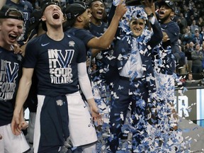 Villanova's Omari Spellman, right, dumps confetti on head coach Jay Wright, holding the trophy after their win over Texas Tech in an NCAA men's college basketball tournament regional final, Sunday, March 25, 2018, in Boston. Villanova won 71-59 to advance to the Final Four.