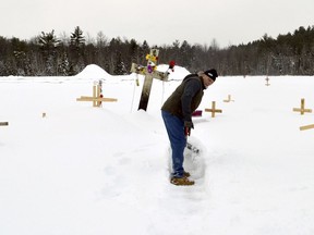File -- In this Feb. 9, 2018 file photo, Oscar "Fred" Butman clears a path in the snow at the memorial he and his family built in Canaan, N.H., for his stepson Jesse James Champney, who was shot dead by police in December of 2017. The memorial, a mix of crosses and signs calling for justice for Champney, stands in an empty field along a rural highway and leads to the spot where Champney was shot four times by New Hampshire State Trooper Christopher O'Toole. In its report on the shooting, the Attorney General's office said Wednesday, March 14, 2018 that O'Toole shot Champney because he feared for his life and found he was legally justified in using deadly force.