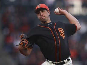San Francisco Giants' Derek Holland works against the Oakland Athletics during the first inning of a spring training baseball game on Monday, March 26, 2018, in San Francisco.