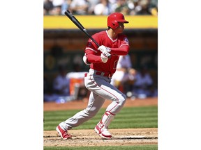 Los Angeles Angels' Shohei Ohtani follows through after hitting a single in his first major league at bat during the second inning of an opening baseball game against the Oakland Athletics, Thursday, March 29, 2018 in Oakland, Calif.