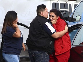 Fernando Juarez, 36, of Napa, center, embraces his 22-year-old sister Vanessa Flores, right, at the Veterans Home of California on Friday March 9, 2018. in Yountville, Calif. Flores, who is a caregiver at the facility, exchanged texts with family while sheltering in place. A gunman took at least three people hostage at the largest veterans home in the United States on Friday, leading to a lockdown of the sprawling grounds in California, authorities said.