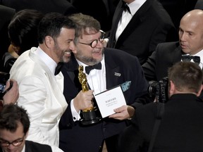 Jimmy Kimmel, left, congratulates Guillermo del Toro in the audience after winning the award for best picture for "The Shape of Water" at the Oscars on Sunday, March 4, 2018, at the Dolby Theatre in Los Angeles.