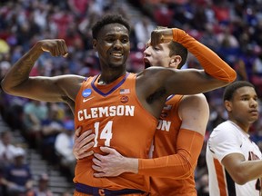 Clemson forward Elijah Thomas, front, celebrates a basket with forward David Skara during the first half of a second-round NCAA men's college basketball tournament game against Auburn on Sunday, March 18, 2018, in San Diego.