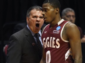 New Mexico State head coach Chris Jans, left, has a word with New Mexico State guard Keyon Jones (0) during the first half of a first-round NCAA college basketball tournament game against Clemson, Friday, March 16, 2018, in San Diego.