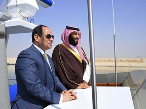 In this photo provided by Egypt's state news agency, MENA, Egyptian President Abdel-Fattah el-Sissi, left, and Saudi Crown Prince Mohammed bin Salman tour the Suez canal near Ismailia, 120 kilometers (75 miles) east of Cairo, Egypt. Egypt gave a warm welcome to Saudi Arabia's Crown Prince Mohammed bin Salman on Monday, with military fanfare and a trip to the Suez Canal meant to underline a growing strategic partnership.
