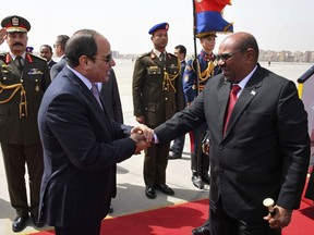 Egyptian President Abdel-Fattah el-Sissi, left, shakes hands with Sudan's President Omar al-Bashir at Cairo Airport, in Cairo, Egypt Monday, March 19, 2018. The two countries look to repair ties that were recently frayed over an upstream Nile dam being built by Ethiopia. At a joint press conference Monday, al-Bashir and Egyptian President Abdel-Fattah el-Sissi vowed to cooperate in managing the effects of the dam, which Egypt fears will cut into its share of the river. (Mohammed Samaha/MENA via AP)