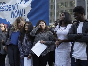 Emi MacLean, attorney with National Day Laborers Organizing Network, from left, stands next to Crista Ramos, Ramos' mother Cristina Morales, from El Salvador, Sherika Blanc, from Haiti, and Mazin Ahmed, from Sudan, at a news conference announcing a lawsuit against the Trump administration over its decision to end a program that lets immigrants live and work legally in the United States outside of a federal courthouse in San Francisco, Monday, March 12, 2018. Ramos, Morales, Blanc and Ahmed are among the plaintiffs alleging the decision to end temporary protected status for El Salvador, Haiti, Nicaragua and Sudan was racially motivated.