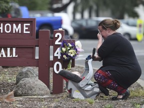 A woman, who declined to give her name, cries after placing flowers at a sign at the Veterans Home of California, the morning after a hostage situation in Yountville, Calif., on Saturday, March 10, 2018.  A daylong siege at The Pathway Home ended Friday evening with the discovery of four bodies, including the gunman, identified as Albert Wong, a former Army rifleman who served a year in Afghanistan in 2011-2012.