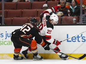 New Jersey Devils' Blake Coleman, right, is defended by Anaheim Ducks' Josh Manson during the first period of an NHL hockey game Sunday, March 18, 2018, in Anaheim, Calif.