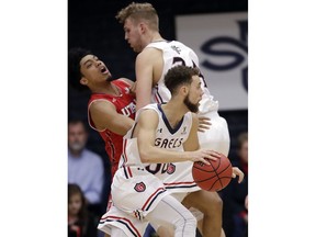 Saint Mary's guard Jordan Ford, center, dribbles around a screen set by teammate Jock Landale on Utah guard Sedrick Barefield during the first half of an NCAA college basketball game in the quarterfinals of the NIT, Wednesday, March 21, 2018, in Moraga, Calif.