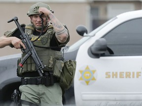 A Pomona police officer gets ready to take position with a shooting suspect in an apartment complex Saturday, March 10, 2018, in Pomona, Calif. The gunman who shot two California police officers, killing one of them, was arrested Saturday after barricading himself in an apartment and holding a SWAT team at bay for more than 15 hours, authorities said.