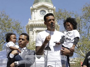 Former NBA player Matt Barnes holds Cairo, one of the sons of police shooting victim Stephon Clark, as he speaks at a rally aimed at ensuring Clark's memory and calling for police reform, Saturday, March 31, 2018, in Sacramento, Calif. The gathering comes nearly two weeks after Clark, who was unarmed, was shot and killed by two Sacramento police officers. Barnes, a Sacramento native, who organized the event, announced he was starting a college scholarship fund for Clark's two sons and the children of parents killed by police nationwide. At left, the Rev. Shane Harris holds Clark's other son, Aiden.