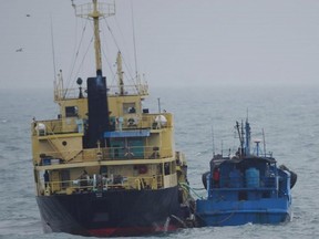 This Feb. 16, 2018 file photo released by Japan's Ministry of Defence shows what it says is the North Korean-flagged tanker Yu Jong 2, left, and Min Ning De You 078 lying alongside in the East China Sea. China says it is "highly concerned" about a reported ship-to-ship transfer on the high seas that could violate U.N. sanctions on North Korea.