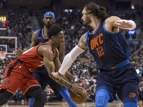 Toronto Raptors guard DeMar DeRozan (left) drives between Oklahoma City Thunder's Corey Brewer and Steven Adams (right) during first half NBA basketball action in Toronto on Sunday, March 18, 2018.