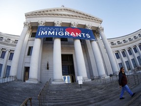 FILE - In this Feb. 26, 2018 file photo, a banner to welcome immigrants is viewed through a fisheye lens over the main entrance to the Denver City and County Building. Four lawmakers from Colorado are meeting with officials at the White House on Thursday, March 8, 2018 to talk about punishing so-called sanctuary cities that limit cooperation with federal immigration officials. Denver has not declared itself to be a sanctuary city but its cooperation with immigration authorities has been criticized by U.S. Attorney Jeff Sessions.