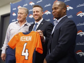 Case Keenum, center, smiles as he holds up his new jersey as John Elway, left, general manager of the Denver Broncos, and head coach Vance Joseph look on during a news conference to introduce Keenum as the new starting quarterback of the team at the organization's headquarters Friday, March 16, 2018, in Englewood, Colo.
